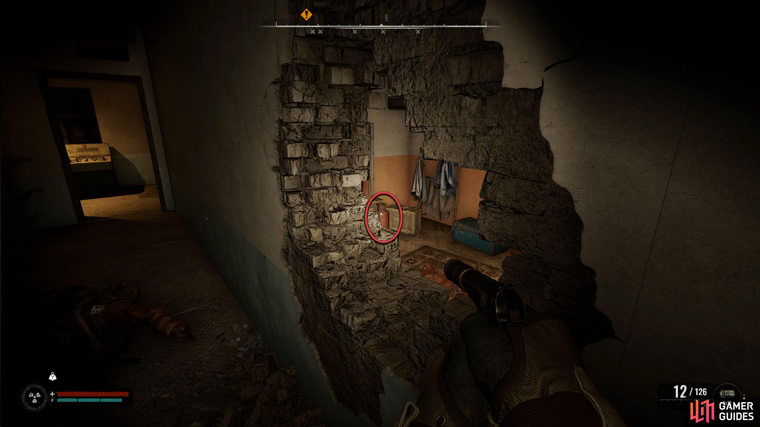 After defeating the zombies, look through the hole and shoot the canister to the left.
