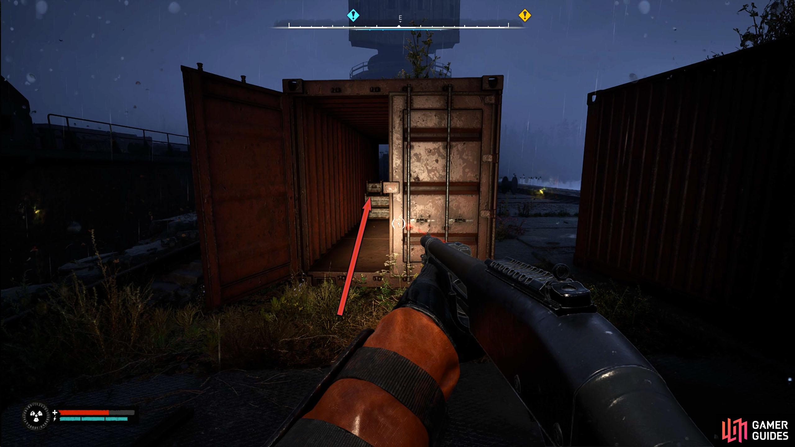 On the dock, go through the red container.