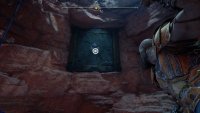 At the top of the wall, look north to smash through a weak wall by grappling to it.