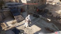 The traitor is hanging out with a guard in the building left of the crane.